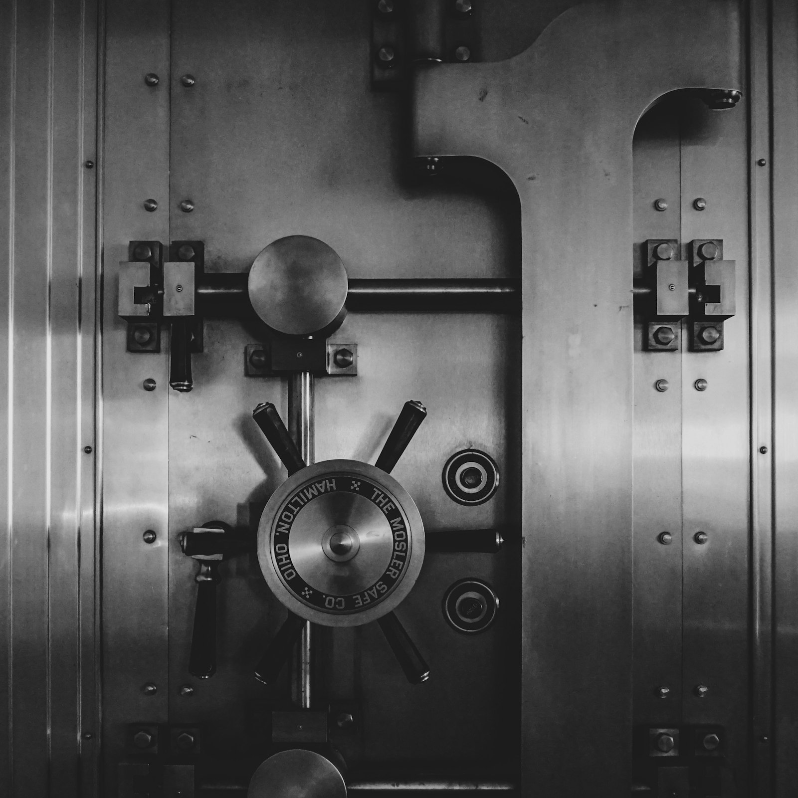 The heavy circular steel door of a bank vault, closed and locked