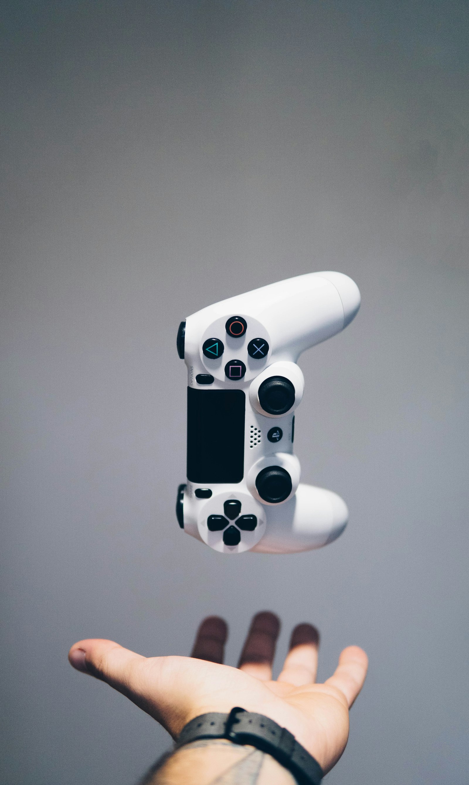 A person holding a game controller, absorbed in playing a video game in a dim room