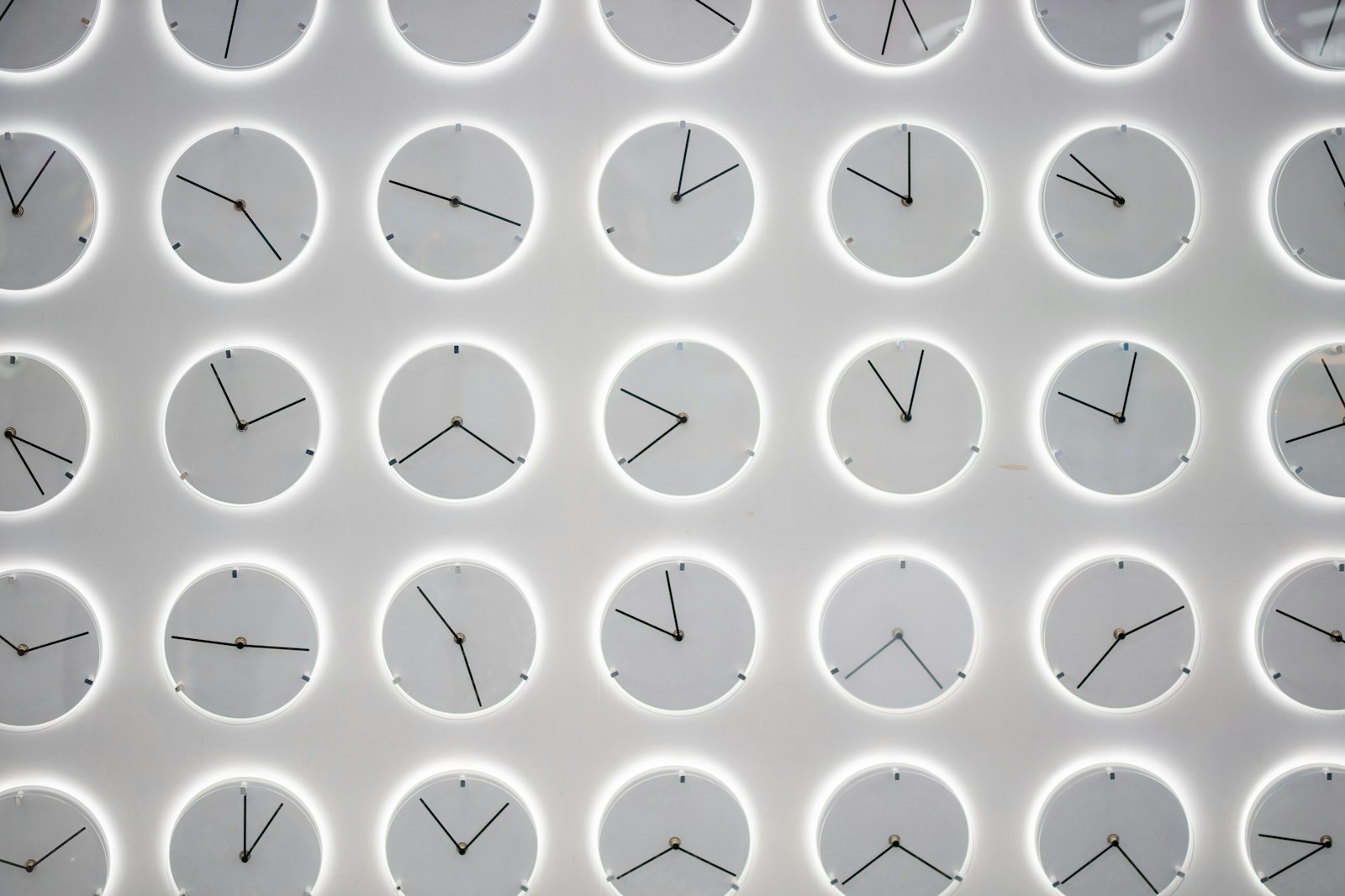 A wall covered in a grid of many clocks, each showing a different time zone